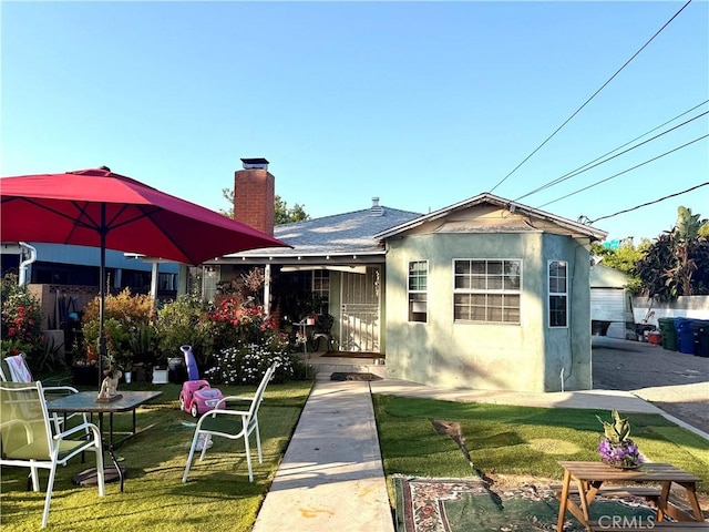 9704 Vena Ave, Arleta, CA 91331 - view of front of home featuring stucco siding, a chimney, and a front yard