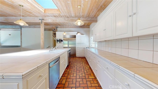 12 Pinto Ln, Rolling Hills Estates, CA 90274 - kitchen featuring built in appliances, brick floors, a skylight, tile countertops, and a wooden ceiling with exposed beams