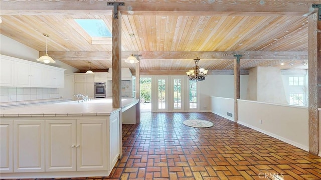 12 Pinto Ln, Rolling Hills Estates, CA 90274 - kitchen featuring a wood ceiling with exposed beams, open floor plan, plenty of natural light, white cabinetry, and light countertops