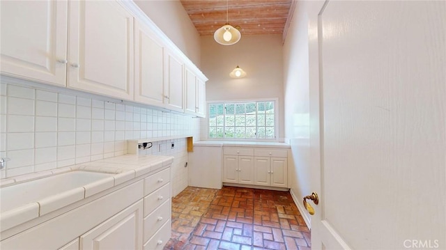12 Pinto Ln, Rolling Hills Estates, CA 90274 - laundry room featuring brick flooring, wood ceiling, and cabinet space