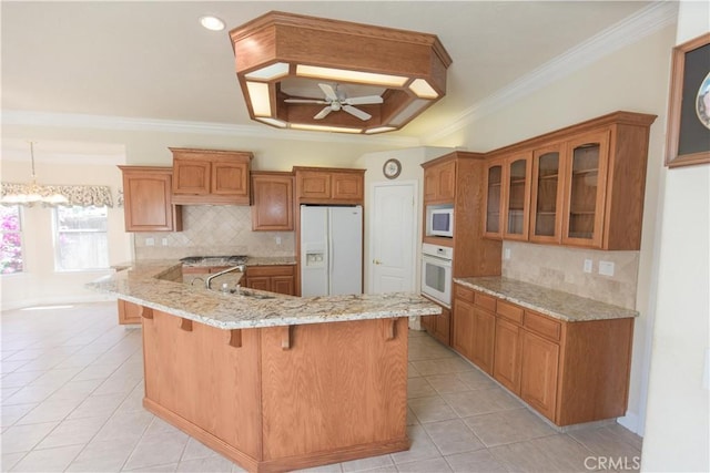 337 W Trenton Ave, Clovis, CA 93619 - kitchen with white appliances, a kitchen breakfast bar, light tile patterned floors, ceiling fan, and ornamental molding