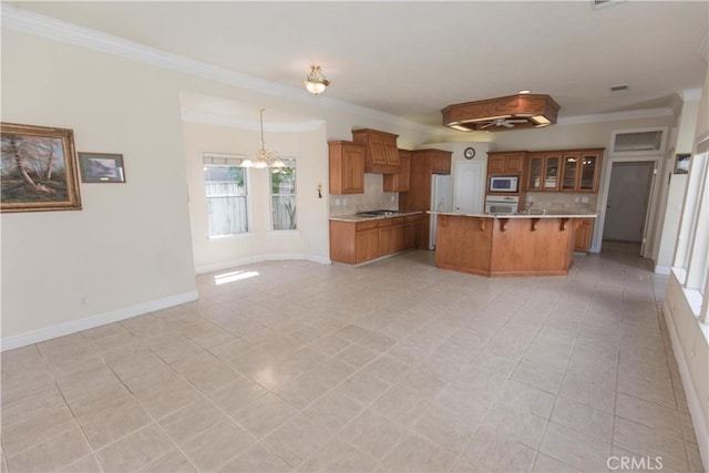 337 W Trenton Ave, Clovis, CA 93619 - kitchen with white appliances, light countertops, backsplash, a kitchen breakfast bar, and brown cabinets