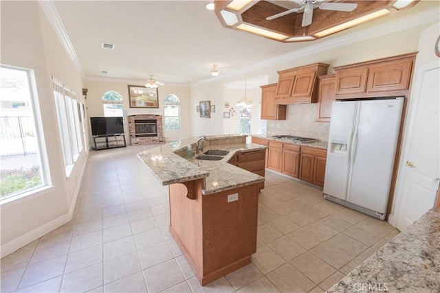 337 W Trenton Ave, Clovis, CA 93619 - kitchen with white refrigerator with ice dispenser, ceiling fan, crown molding, a fireplace, and light tile patterned flooring