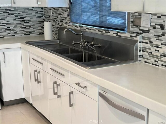 1553 Spyglass, Palm Springs, CA 92264 - kitchen with white dishwasher, tasteful backsplash, white cabinets, and light countertops