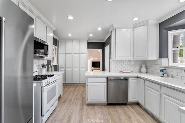 4455 Atoll Ave, Sherman Oaks, CA 91423 - kitchen with appliances with stainless steel finishes, white cabinetry, ornamental molding, light countertops, and backsplash