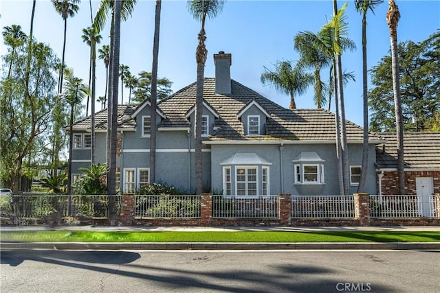4455 Atoll Ave, Sherman Oaks, CA 91423 - view of property exterior featuring stucco siding, a fenced front yard, a chimney, and a tile roof