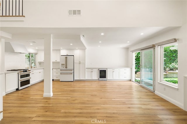 19464 Turtle Ridge Ln, Porter Ranch, CA 91326 - unfurnished living room featuring wine cooler, light wood finished floors, recessed lighting, and a sink