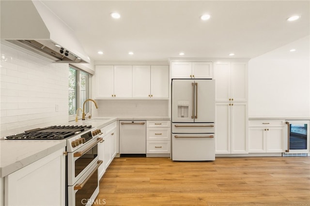 19464 Turtle Ridge Ln, Porter Ranch, CA 91326 - kitchen with white appliances, wall chimney range hood, wine cooler, a sink, and white cabinetry