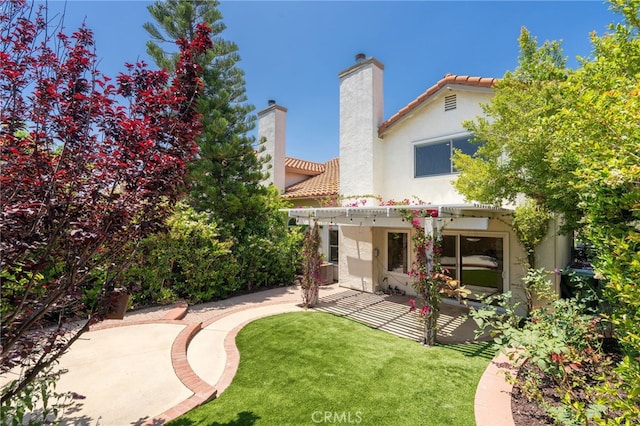 19464 Turtle Ridge Ln, Porter Ranch, CA 91326 - rear view of property featuring a patio area, stucco siding, a tile roof, a lawn, and a chimney