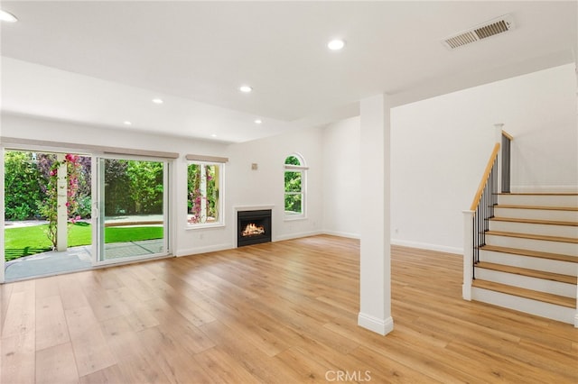 19464 Turtle Ridge Ln, Porter Ranch, CA 91326 - unfurnished living room featuring light wood-type flooring, recessed lighting, baseboards, stairs, and a warm lit fireplace
