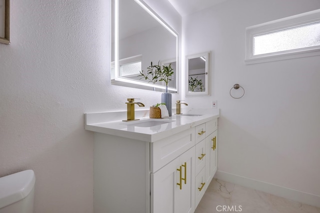 24162 Twig St, Lake Forest, CA 92630 - bathroom with marble look tile flooring, double vanity, toilet, and baseboards