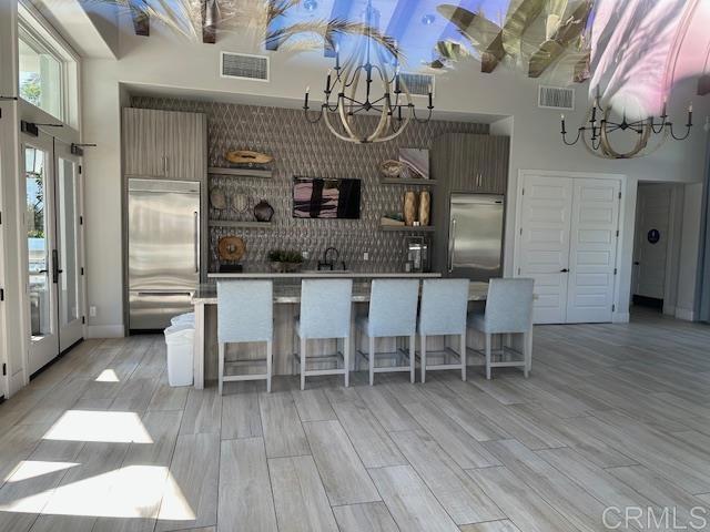 2527 Wellspring St, Carlsbad, CA 92010 - kitchen with stainless steel built in refrigerator, a chandelier, a sink, and a high ceiling