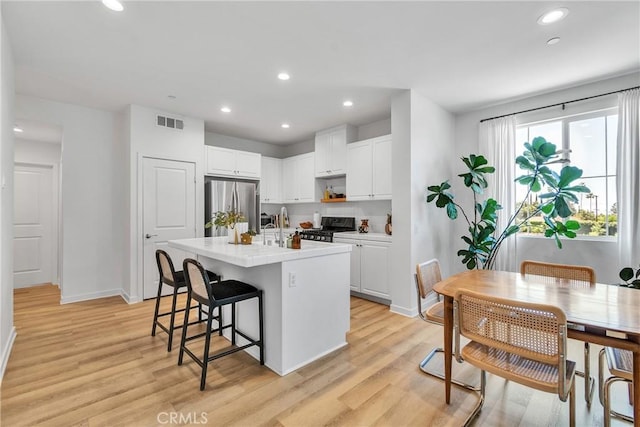 962 Newberry Ln, Claremont, CA 91711 - kitchen featuring stainless steel refrigerator, range, light wood finished floors, white cabinets, and recessed lighting