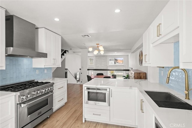 2310 Vanderbilt Ln Unit 4, Redondo Beach, CA 90278 - kitchen with stainless steel range, wall chimney range hood, a peninsula, backsplash, and white cabinetry
