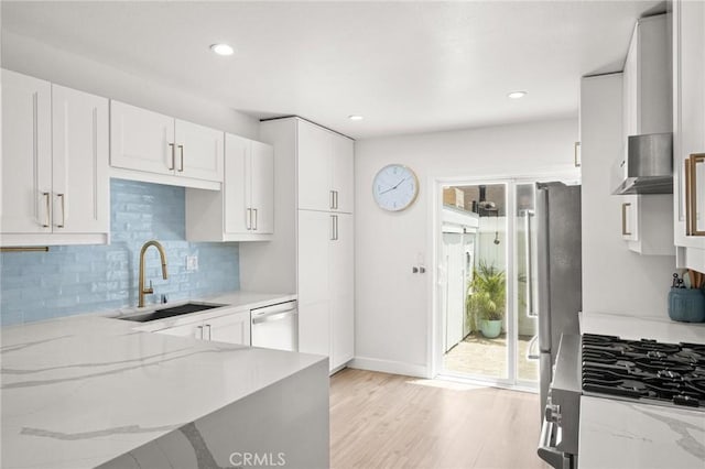 2310 Vanderbilt Ln Unit 4, Redondo Beach, CA 90278 - kitchen with white dishwasher, backsplash, light stone counters, stove, and light wood-type flooring
