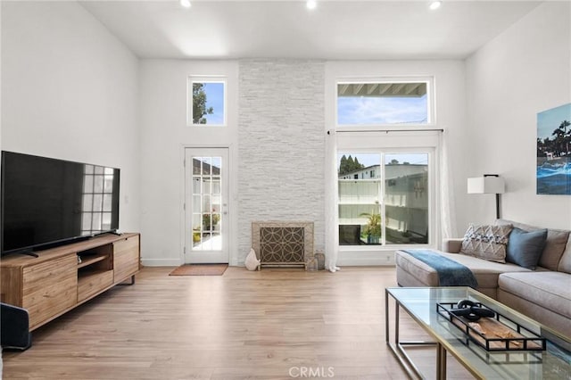 2310 Vanderbilt Ln Unit 4, Redondo Beach, CA 90278 - living room featuring light wood-style flooring, a fireplace, a high ceiling, and recessed lighting