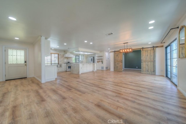1043 Meadowview Ct, Corona, CA 92878 - unfurnished living room with a barn door, light wood-style floors, recessed lighting, and crown molding
