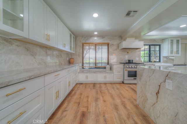 1043 Meadowview Ct, Corona, CA 92878 - kitchen with stainless steel stove, tasteful backsplash, white cabinetry, light wood finished floors, and recessed lighting