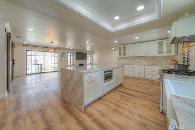 1043 Meadowview Ct, Corona, CA 92878 - kitchen featuring a kitchen island, ornamental molding, premium range hood, open floor plan, and stainless steel microwave