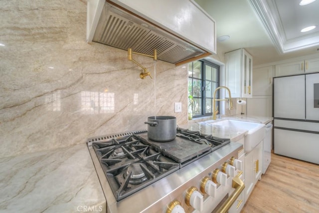 1043 Meadowview Ct, Corona, CA 92878 - kitchen with stove, stainless steel fridge, custom exhaust hood, white cabinetry, and light stone counters