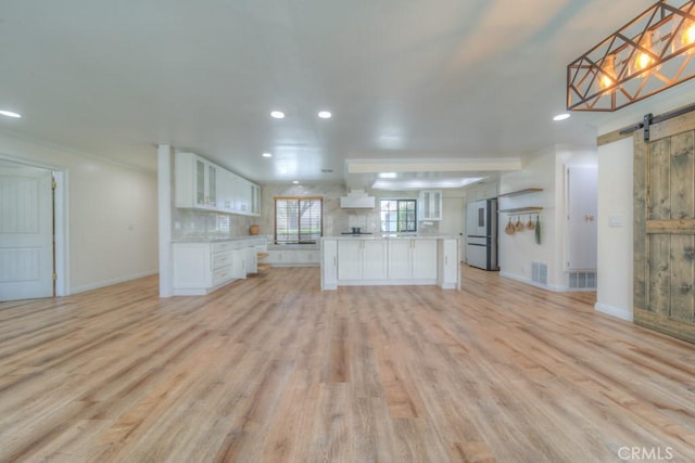 1043 Meadowview Ct, Corona, CA 92878 - unfurnished living room with a barn door, recessed lighting, and light wood-style floors