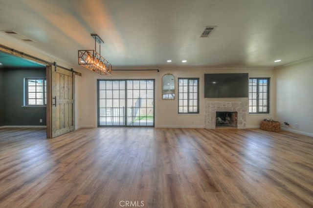1043 Meadowview Ct, Corona, CA 92878 - unfurnished living room featuring a barn door, healthy amount of natural light, ornamental molding, wood finished floors, and recessed lighting