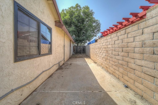 1043 Meadowview Ct, Corona, CA 92878 - view of side of home with stucco siding and a patio area