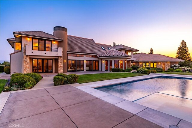 2340 Battering Rock Rd, Templeton, CA 93465 - back of house with a balcony, stone siding, a tiled roof, stucco siding, and an outdoor pool
