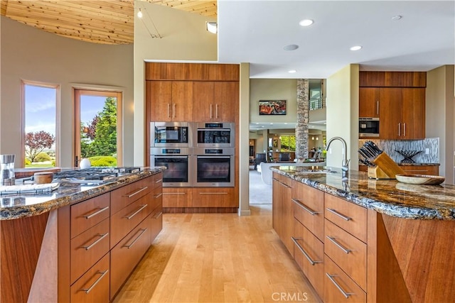 2340 Battering Rock Rd, Templeton, CA 93465 - kitchen featuring modern cabinets, a sink, a center island with sink, brown cabinets, and recessed lighting