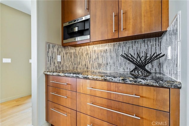2340 Battering Rock Rd, Templeton, CA 93465 - kitchen with dark stone countertops, brown cabinetry, decorative backsplash, and light wood finished floors