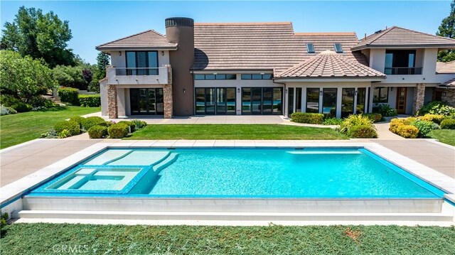 2340 Battering Rock Rd, Templeton, CA 93465 - back of house featuring a balcony, a patio area, a yard, stone siding, and a pool with connected hot tub