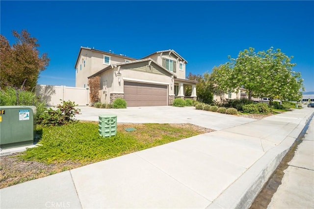 1172 Poinsettia Cir, Calimesa, CA 92320 - view of front facade featuring stone siding, stucco siding, driveway, and a garage