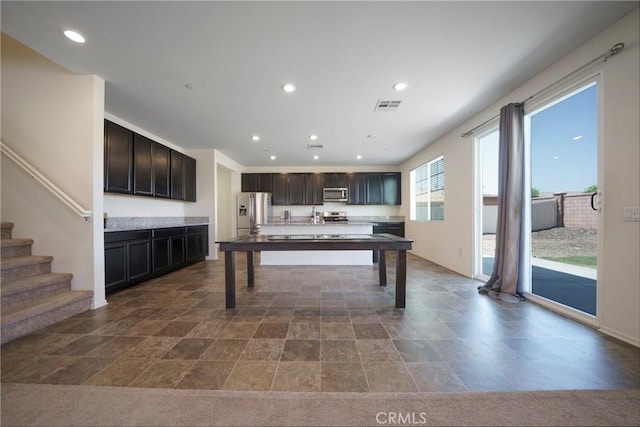 1172 Poinsettia Cir, Calimesa, CA 92320 - kitchen with stainless steel appliances, recessed lighting, a center island with sink, dark stone finish flooring, and light countertops