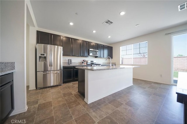 1172 Poinsettia Cir, Calimesa, CA 92320 - kitchen featuring appliances with stainless steel finishes, light stone countertops, recessed lighting, a center island with sink, and stone finish floors