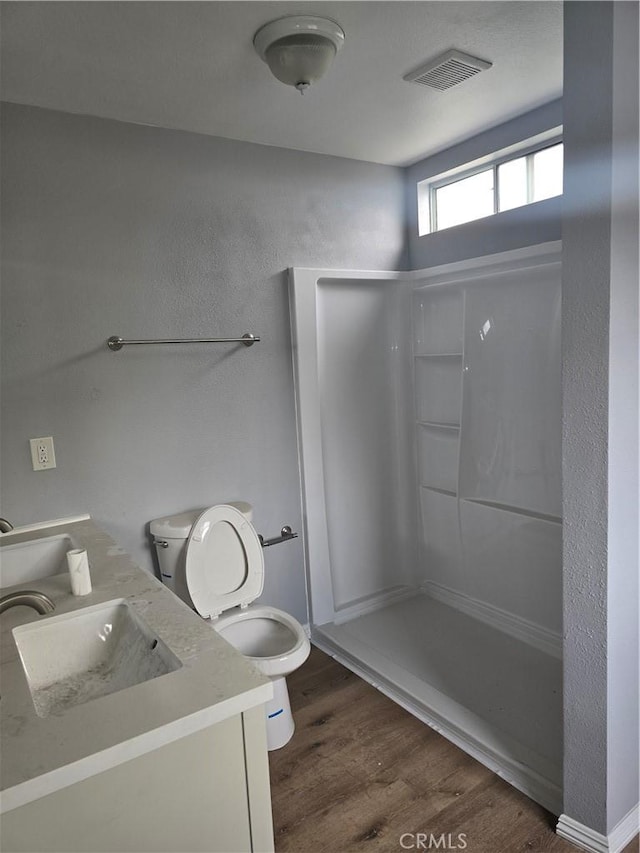 1126 S Dacotah St, Los Angeles, CA 90023 - bathroom featuring toilet, wood finished floors, vanity, and a shower