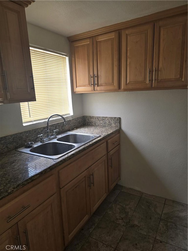 1126 S Dacotah St, Los Angeles, CA 90023 - kitchen with a sink, dark countertops, brown cabinets, and dark stone finish floors
