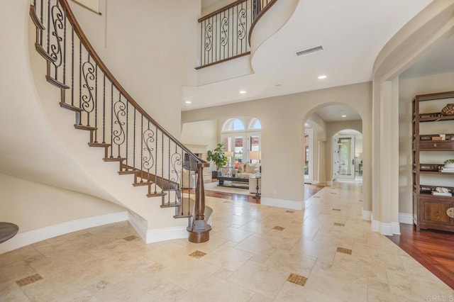 6286 Belmont Trail Ct, San Diego, CA 92130 - foyer entrance featuring arched walkways, baseboards, stairs, stone tile flooring, and recessed lighting