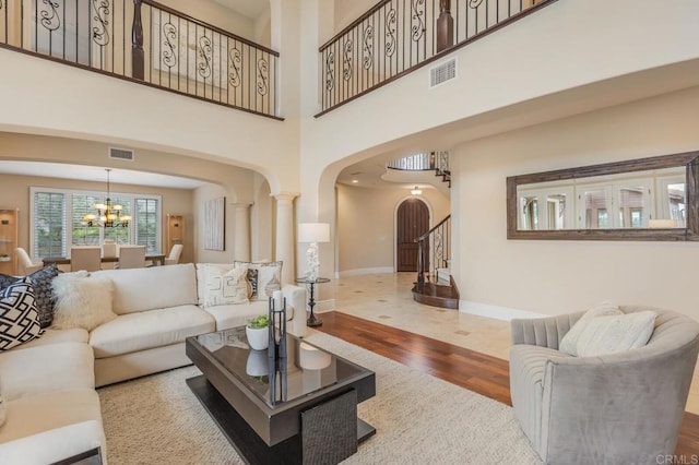 6286 Belmont Trail Ct, San Diego, CA 92130 - living room with arched walkways, wood finished floors, baseboards, a chandelier, and stairs