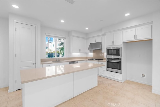 148 Stage, Irvine, CA 92618 - kitchen featuring appliances with stainless steel finishes, under cabinet range hood, a sink, white cabinetry, and a kitchen island