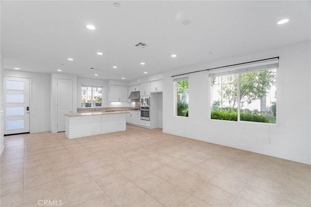 148 Stage, Irvine, CA 92618 - kitchen featuring oven, recessed lighting, white cabinets, under cabinet range hood, and light countertops