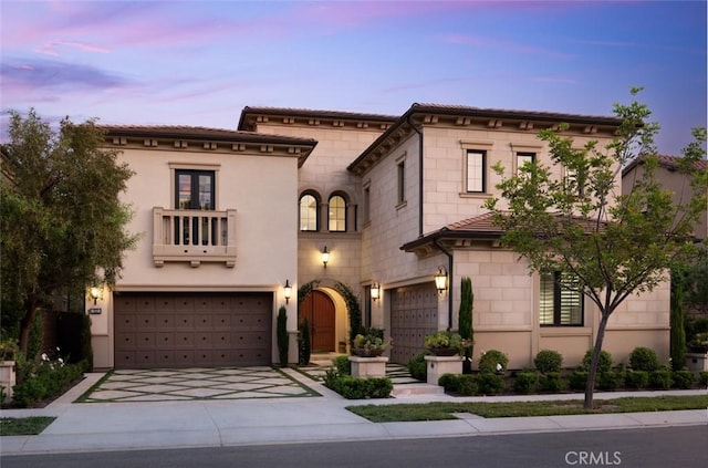112 Mountain Sky, Irvine, CA 92602 - view of front facade featuring a garage, a balcony, concrete driveway, stone siding, and stucco siding