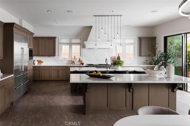 112 Mountain Sky, Irvine, CA 92602 - kitchen featuring a spacious island, light countertops, tasteful backsplash, appliances with stainless steel finishes, and a breakfast bar area