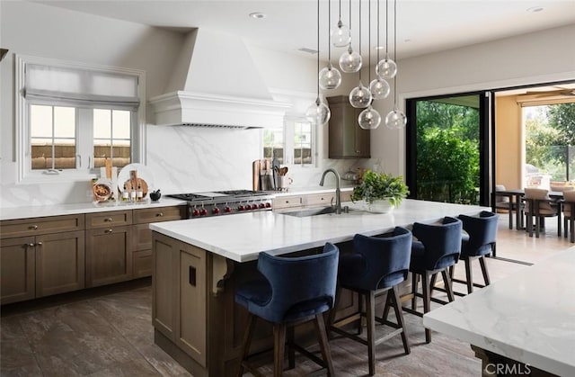 112 Mountain Sky, Irvine, CA 92602 - kitchen with custom exhaust hood, a kitchen bar, tasteful backsplash, an island with sink, and pendant lighting