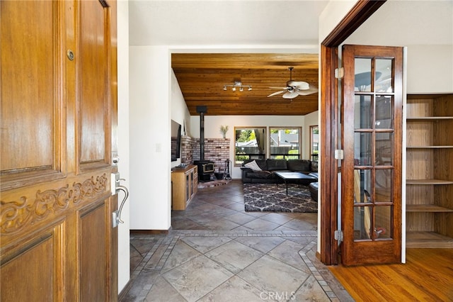 833 Saint Amant Dr, Chico, CA 95926 - foyer entrance with a wood stove, a ceiling fan, vaulted ceiling, and stone tile floors