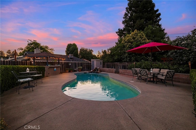 833 Saint Amant Dr, Chico, CA 95926 - pool at dusk featuring a patio, a fenced backyard, a shed, and a gazebo