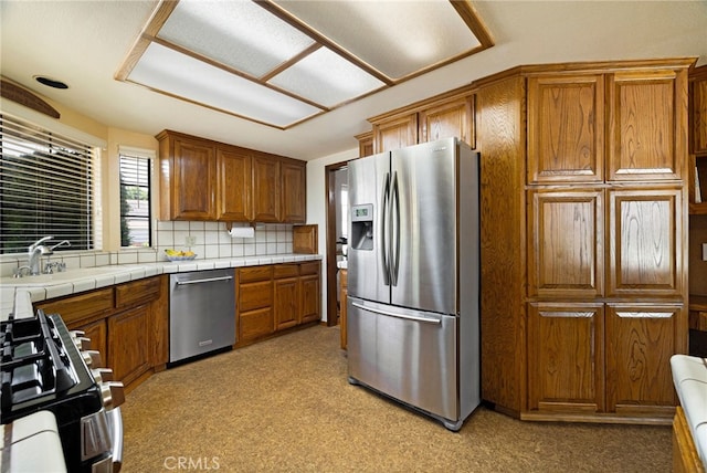 833 Saint Amant Dr, Chico, CA 95926 - kitchen featuring appliances with stainless steel finishes, brown cabinets, light carpet, and backsplash