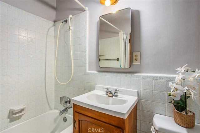3071 Belle St, San Bernardino, CA 92404 - bathroom featuring shower / bath combination with curtain, vanity, tile walls, toilet, and a wainscoted wall