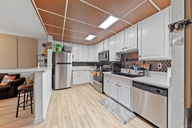 1845 Bayview Heights Dr Unit 110, San Diego, CA 92105 - kitchen featuring appliances with stainless steel finishes, light countertops, decorative backsplash, and light wood finished floors