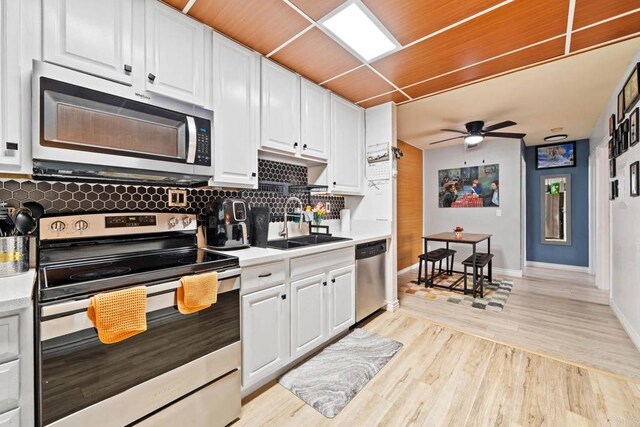 1845 Bayview Heights Dr Unit 110, San Diego, CA 92105 - kitchen with appliances with stainless steel finishes, ceiling fan, decorative backsplash, light countertops, and white cabinetry