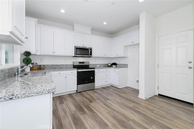 16050 Aventurine Ln, Chino, CA 91708 - kitchen featuring appliances with stainless steel finishes, a sink, white cabinetry, light stone countertops, and light wood-style floors
